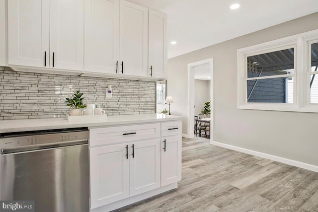 kitchen featuring stainless steel dishwasher, white cabinetry, light countertops, decorative backsplash, and recessed lighting