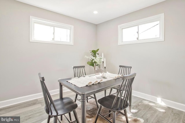 dining area with baseboards, plenty of natural light, and wood finished floors