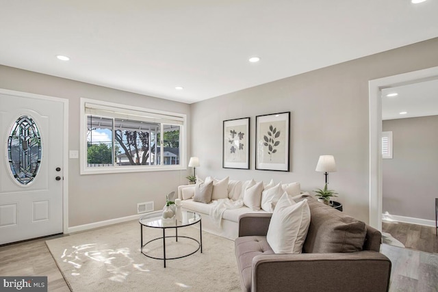 living area featuring light wood finished floors, baseboards, and recessed lighting