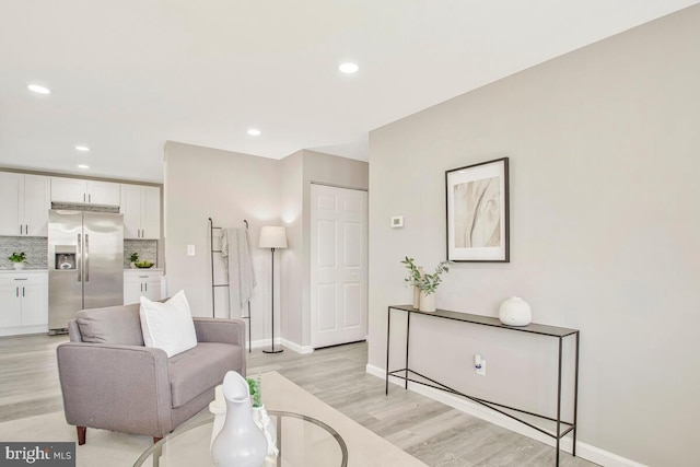 living room with light wood-style floors, baseboards, and recessed lighting