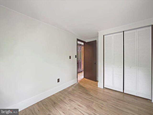 106 Monacan Trl, Hedgesville, WV 25427 - unfurnished bedroom with baseboards, light wood-style floors, a closet, and ornamental molding