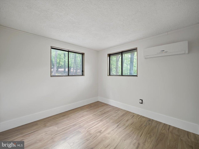 106 Monacan Trl, Hedgesville, WV 25427 - unfurnished room featuring a wall unit AC, light wood finished floors, a textured ceiling, and baseboards