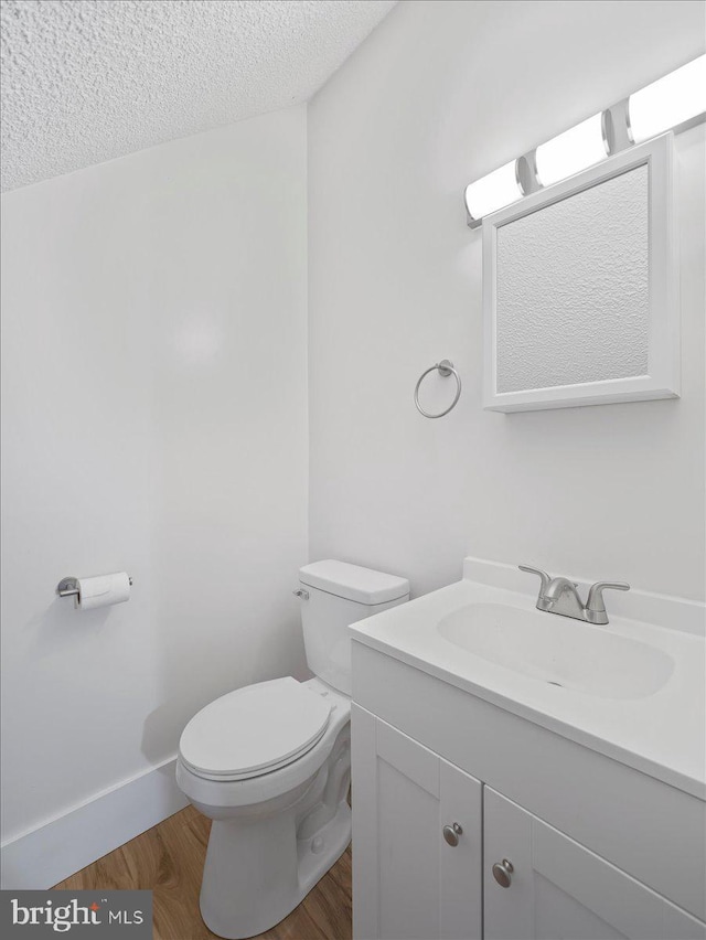 106 Monacan Trl, Hedgesville, WV 25427 - half bath featuring toilet, a textured ceiling, vanity, and wood finished floors
