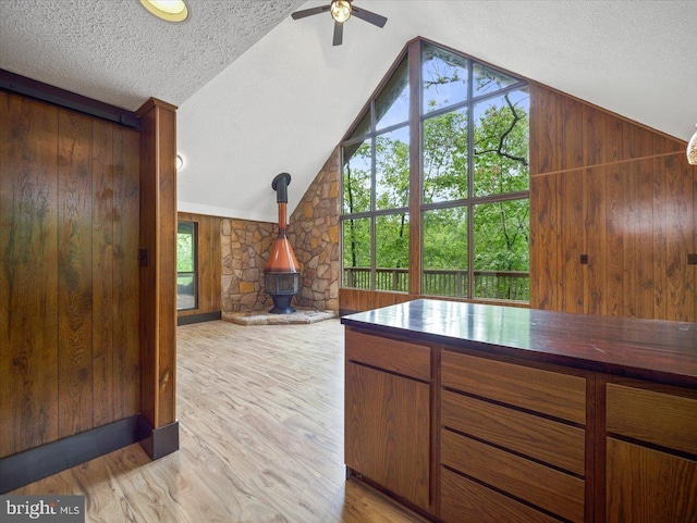 106 Monacan Trl, Hedgesville, WV 25427 - kitchen featuring a wood stove, plenty of natural light, lofted ceiling, wooden walls, and ceiling fan