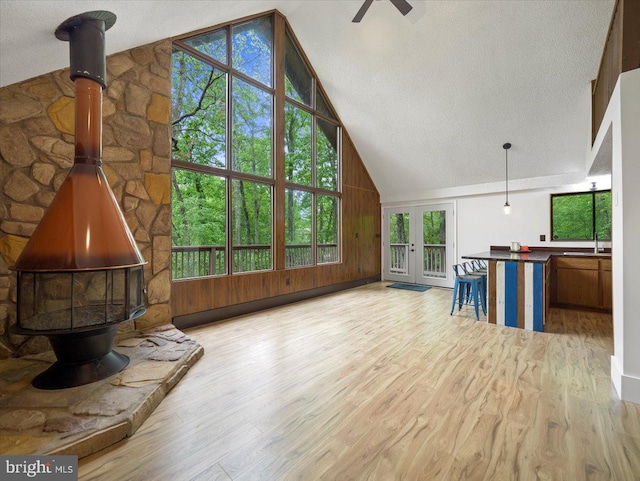 106 Monacan Trl, Hedgesville, WV 25427 - unfurnished living room featuring a wood stove, wood finished floors, ceiling fan, healthy amount of natural light, and high vaulted ceiling