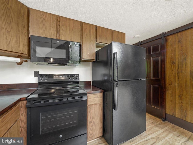 106 Monacan Trl, Hedgesville, WV 25427 - kitchen with black appliances, light wood-type flooring, dark countertops, brown cabinets, and a textured ceiling