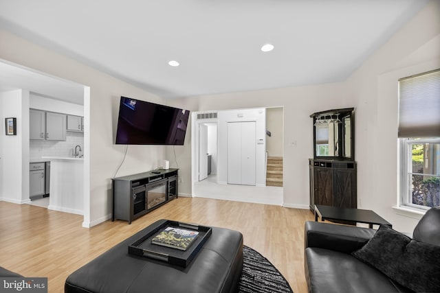 living room with light wood finished floors, stairs, recessed lighting, and baseboards