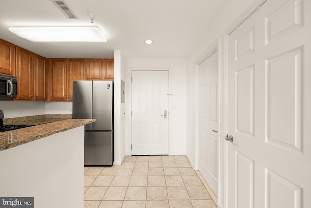 11710 Old Georgetown Rd Unit 1504, North Bethesda, MD 20852 - kitchen with stainless steel appliances, recessed lighting, dark stone countertops, brown cabinetry, and light tile patterned floors