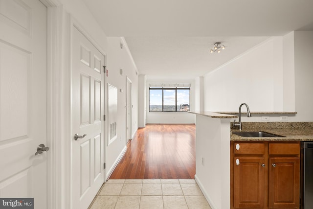 11710 Old Georgetown Rd Unit 1504, North Bethesda, MD 20852 - kitchen featuring a sink, brown cabinets, light tile patterned flooring, light stone counters, and ornamental molding