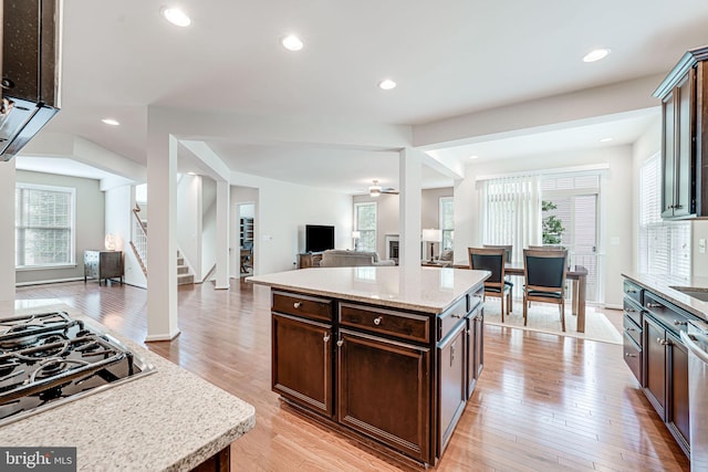 14762 Bell Tower Rd, Woodbridge, VA 22193 - kitchen featuring open floor plan, dark brown cabinetry, light wood-type flooring, black gas stovetop, and light stone countertops