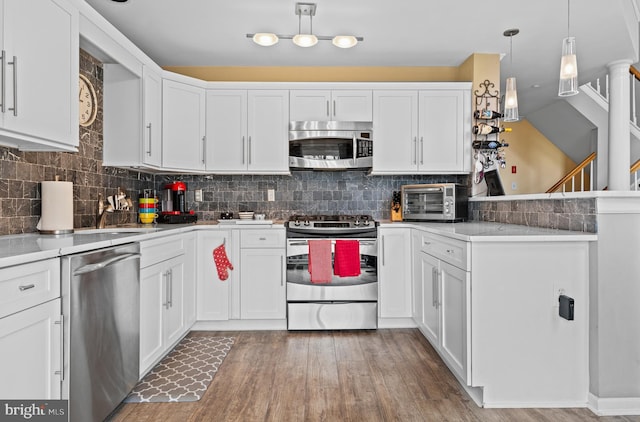171 Timothy Cir, Wayne, PA 19087 - kitchen featuring appliances with stainless steel finishes, a peninsula, white cabinets, light wood finished floors, and light countertops