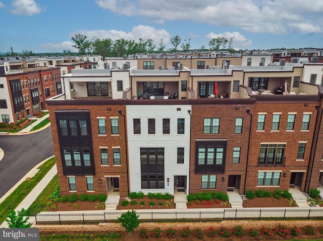 view of building exterior with a fenced front yard and a residential view