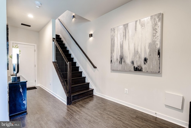 stairway featuring baseboards and wood finished floors
