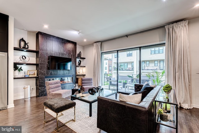 living area featuring wood finished floors, a tile fireplace, baseboards, and recessed lighting