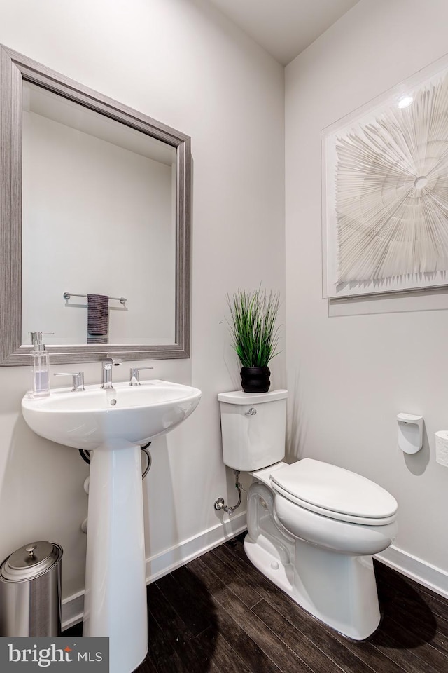 bathroom featuring toilet, baseboards, and wood finished floors