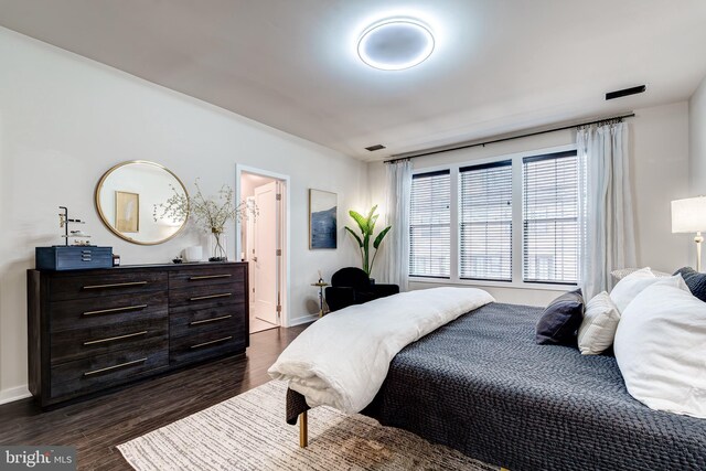 bedroom with dark wood finished floors and baseboards