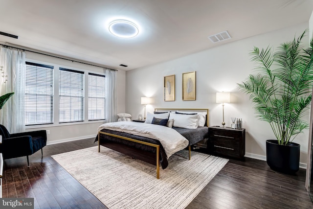 bedroom with dark wood-style flooring and baseboards