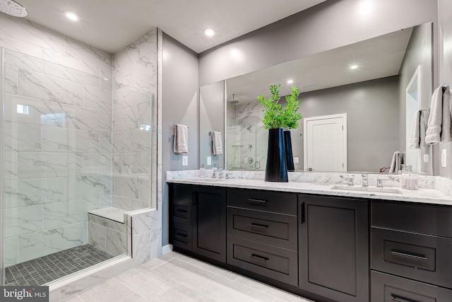 bathroom with a marble finish shower, double vanity, and recessed lighting