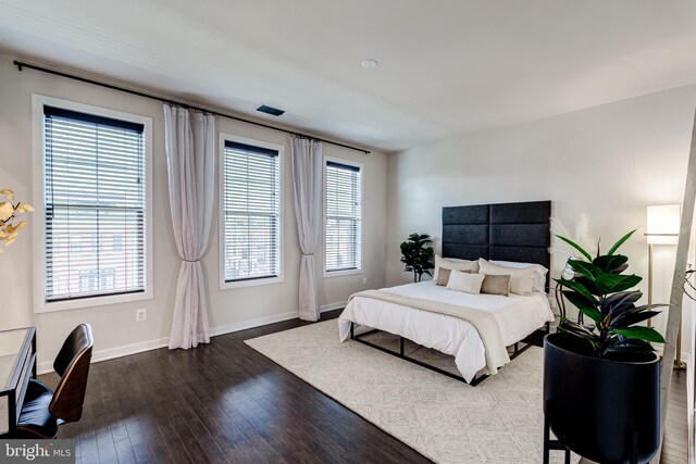 bedroom with dark wood-style flooring and baseboards