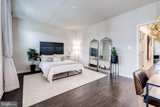 bedroom with wood finished floors and baseboards