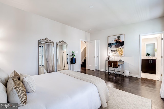 bedroom with wood finished floors, baseboards, and connected bathroom