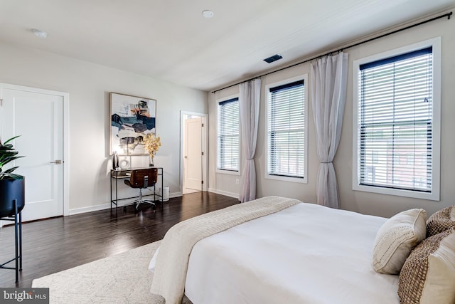 bedroom with wood finished floors and baseboards