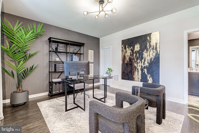 office space with wood finished floors, a chandelier, baseboards, and an accent wall