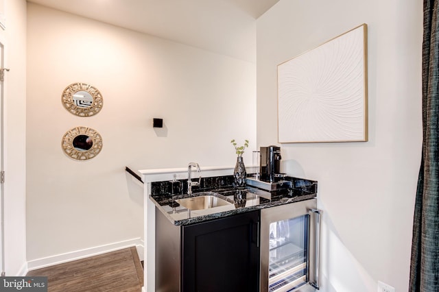 indoor wet bar with wine cooler, wood finished floors, and baseboards
