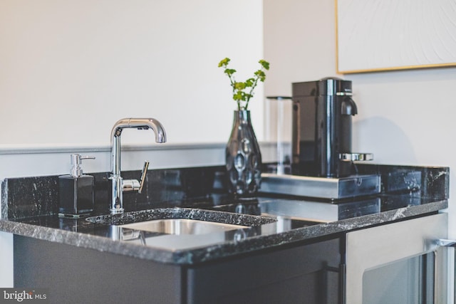kitchen view of dark stone counters and a sink