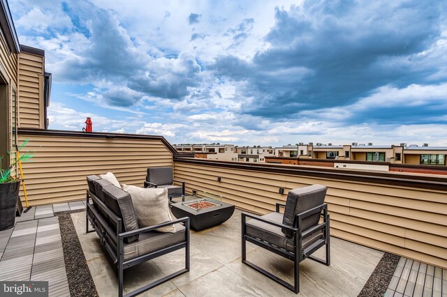 view of patio featuring an outdoor fire pit and a residential view