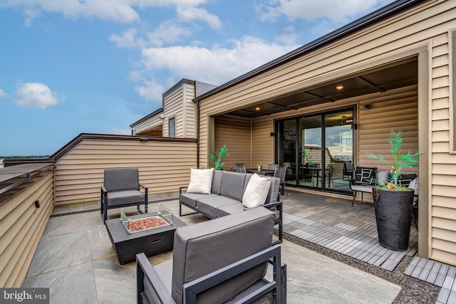 view of patio / terrace with an outdoor living space with a fire pit and a deck