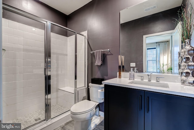 bathroom with a shower stall, toilet, vanity, and wood finished floors