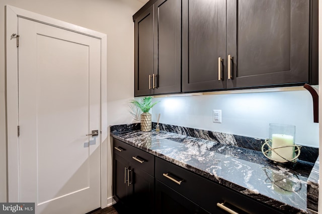 kitchen with dark stone countertops and dark brown cabinets