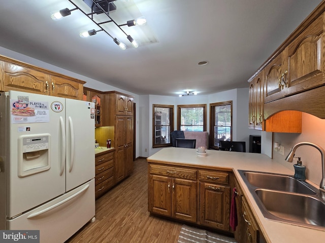 105 Woodview Dr, Harrington, DE 19952 - kitchen featuring white refrigerator with ice dispenser, a sink, a peninsula, wood finished floors, and light countertops