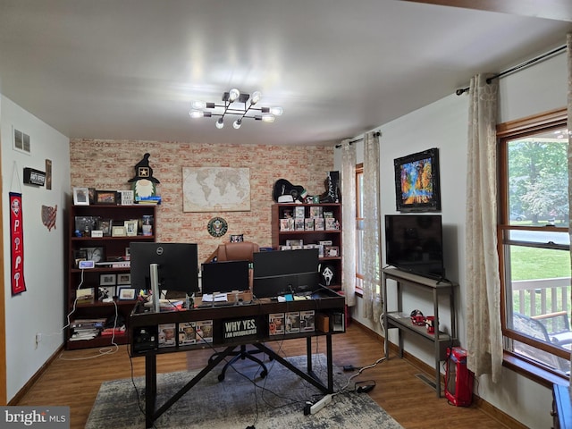 105 Woodview Dr, Harrington, DE 19952 - office space with baseboards, wood finished floors, a chandelier, and brick wall