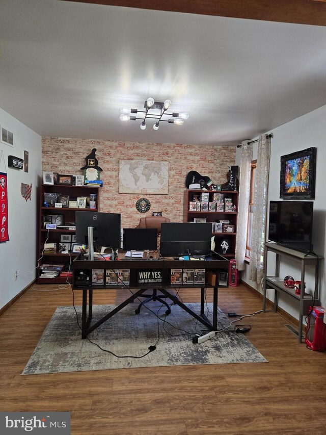 105 Woodview Dr, Harrington, DE 19952 - office with wood finished floors, brick wall, baseboards, and a chandelier