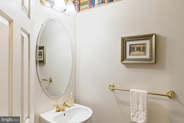 bathroom with a sink and wallpapered walls