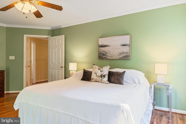 bedroom featuring wood finished floors, ornamental molding, baseboards, and ceiling fan