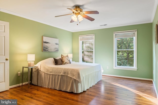 bedroom featuring wood finished floors, ornamental molding, baseboards, and a ceiling fan