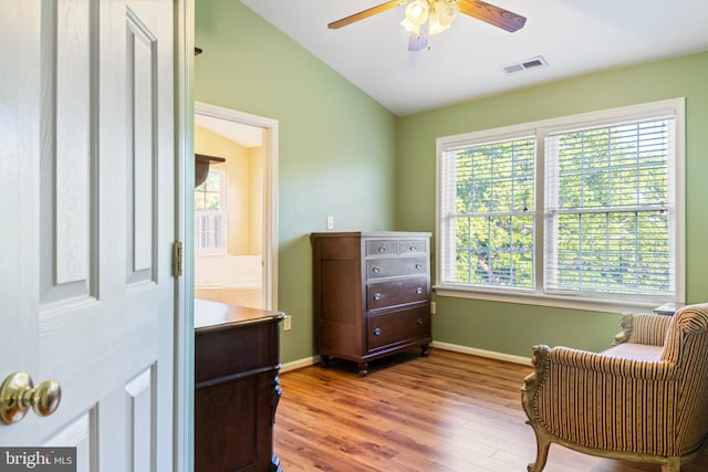 living area with a ceiling fan, wood finished floors, baseboards, and lofted ceiling