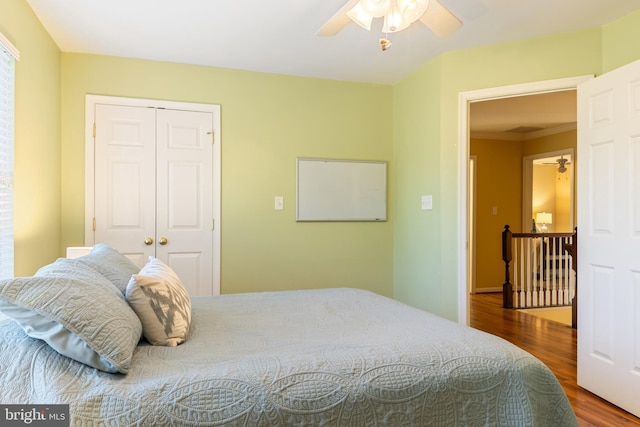 bedroom featuring wood finished floors, a closet, crown molding, and a ceiling fan