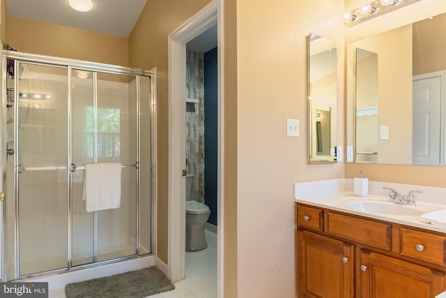 full bathroom featuring a stall shower, toilet, vanity, and tile patterned flooring
