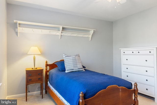 bedroom with light colored carpet and baseboards