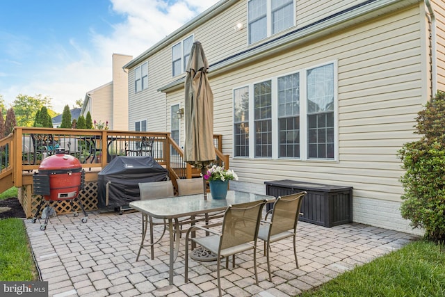 view of patio / terrace with a grill, a wooden deck, and outdoor dining space