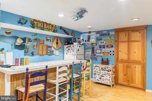 indoor dry bar featuring freestanding refrigerator, light wood-style floors, and recessed lighting