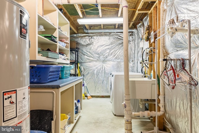 unfinished basement featuring gas water heater, a sink, and washer / dryer