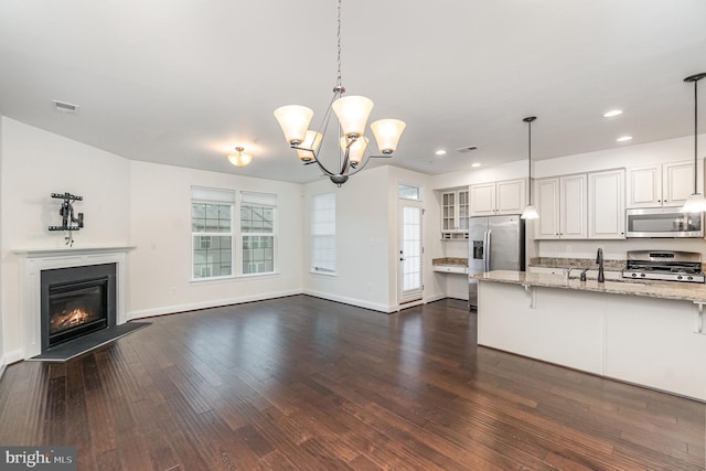 1427 Chanery Ct, Odenton, MD 21113 - kitchen featuring appliances with stainless steel finishes, dark wood finished floors, open floor plan, light stone countertops, and a sink