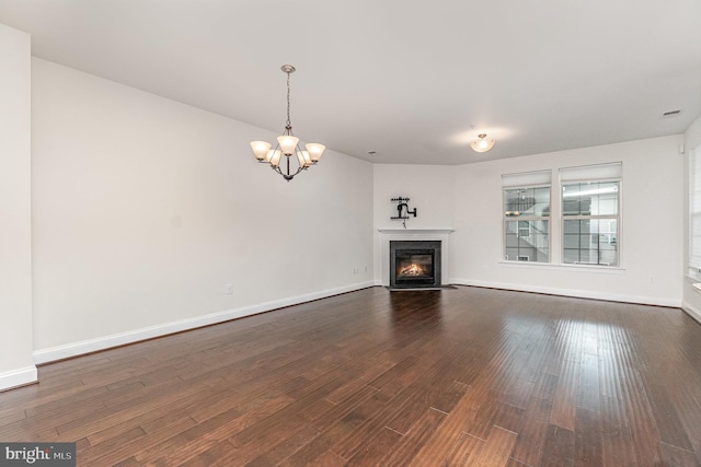 1427 Chanery Ct, Odenton, MD 21113 - unfurnished living room with a chandelier, dark wood-type flooring, a glass covered fireplace, and baseboards