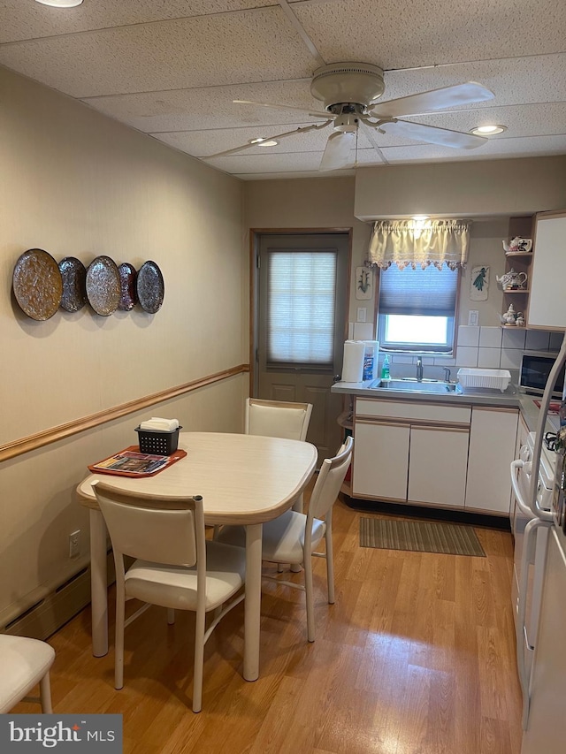 dining room featuring light wood-type flooring, ceiling fan, and baseboard heating