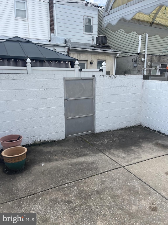 garage with fence, central air condition unit, and a gate